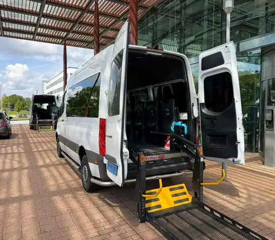 Professionele rolstoeltaxi chauffeur helpt klant in Nieuw-Vennep